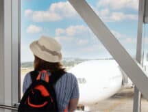 passenger in the airport terminal hall looks at the plane