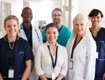 Portrait Of Medical Team Standing In Hospital Corridor.