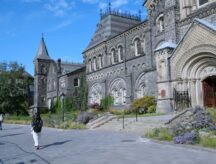 Students walk about a pathway in front of University of Toronto