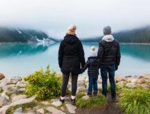 Family stares out over a lake