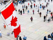 A group of people walking through a popular square in Canada.