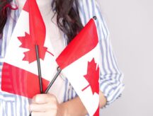 A picture of a girl holding two Canadian flags